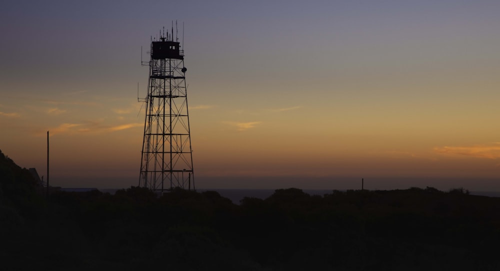 a tall tower sitting on top of a lush green hillside