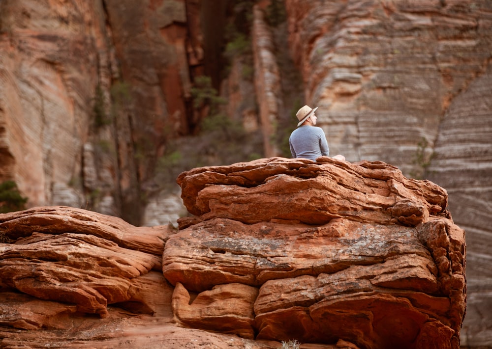Una persona sentada en la cima de una gran roca
