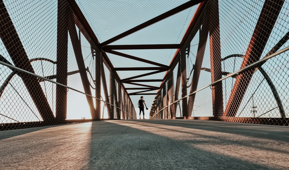 two people standing on a bridge looking at the sky