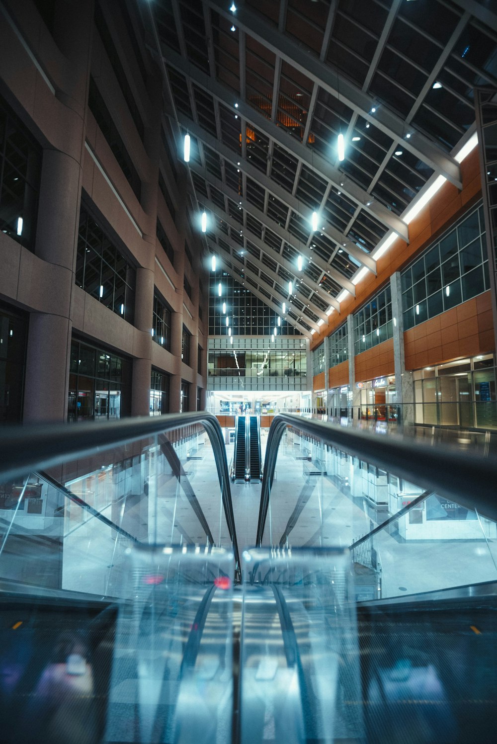 an escalator in a large building with lots of windows