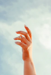 a woman's hand holding a ring in the air