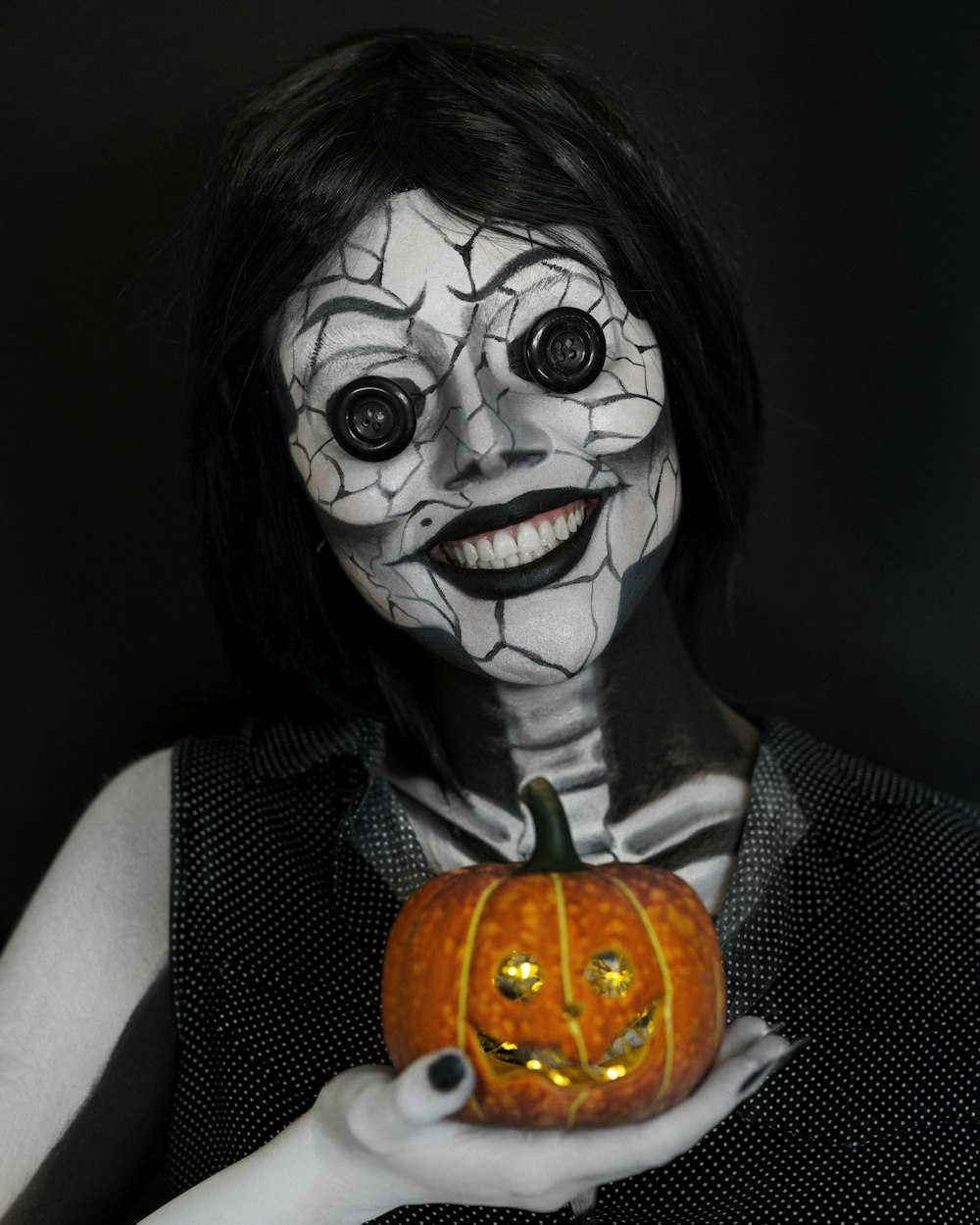 a woman in a halloween costume holding a pumpkin