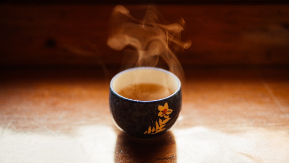 a cup of coffee with steam rising from it