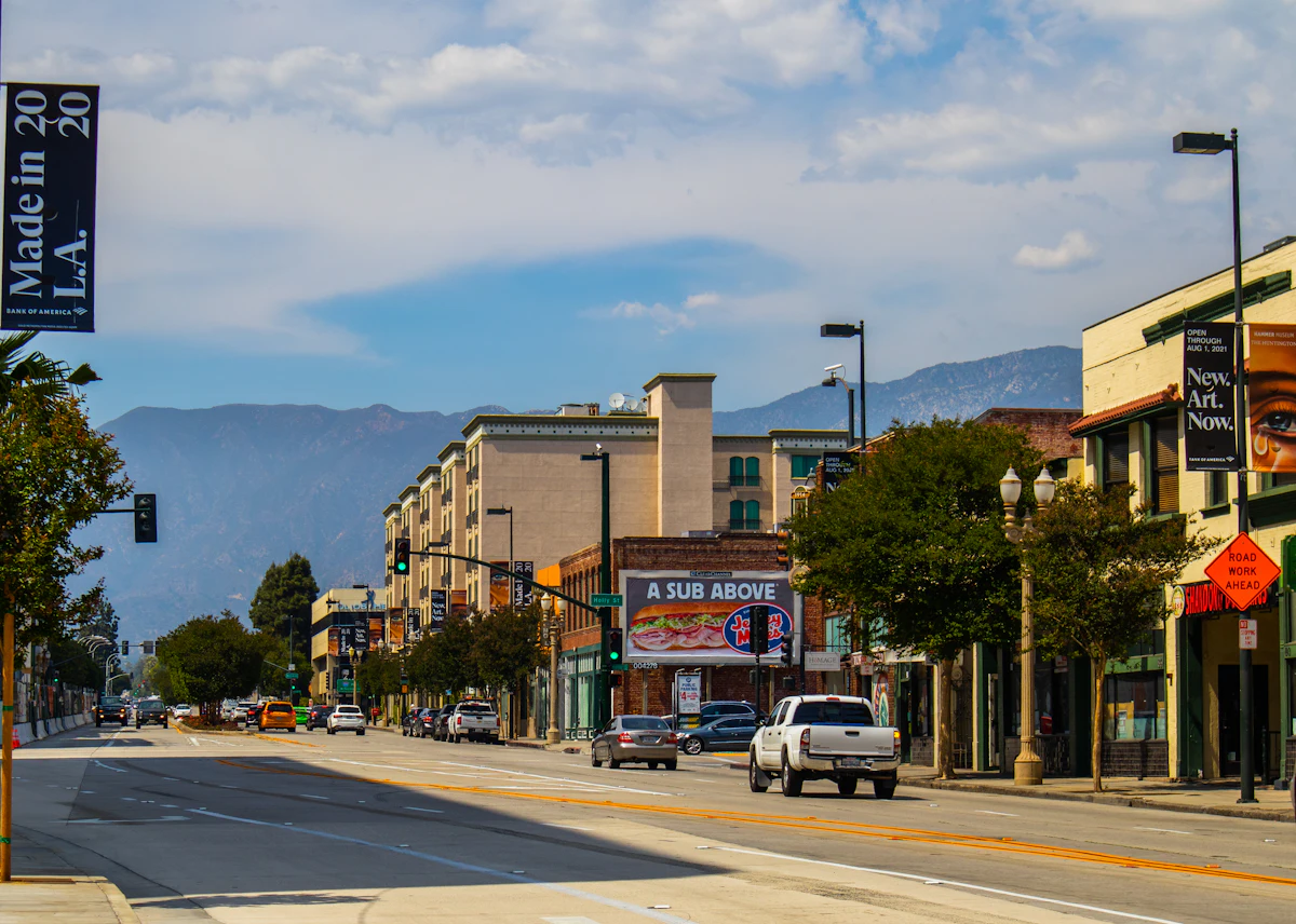 A tree-lined street with the San Gabriel Mountains in the distance