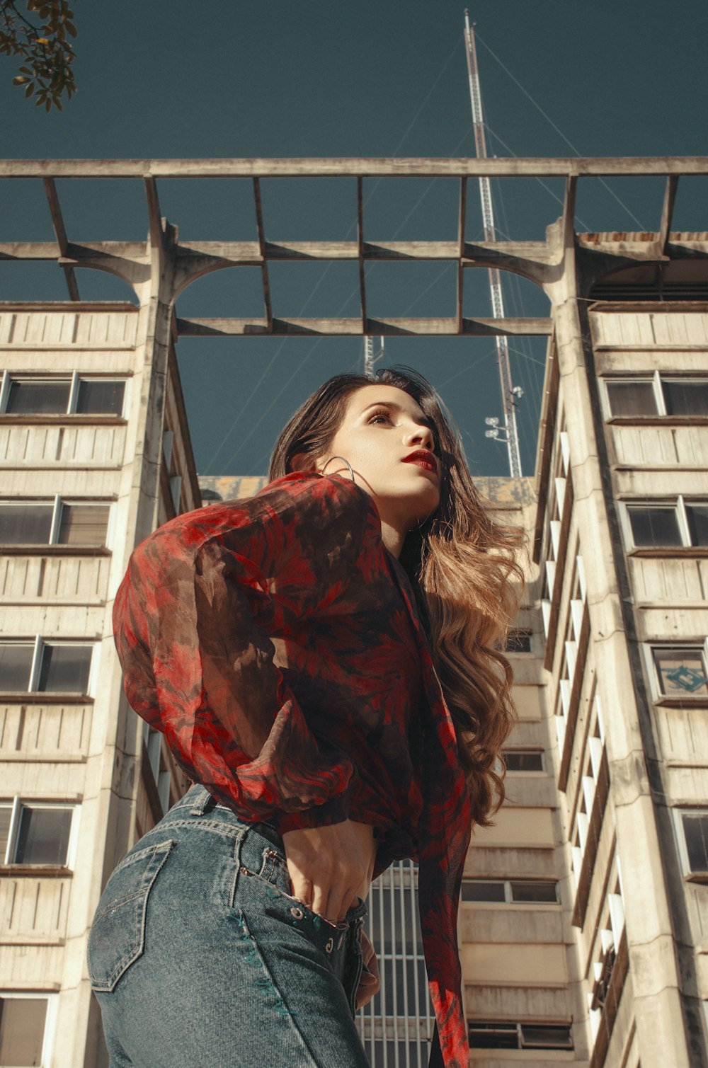 Une femme debout devant un grand immeuble