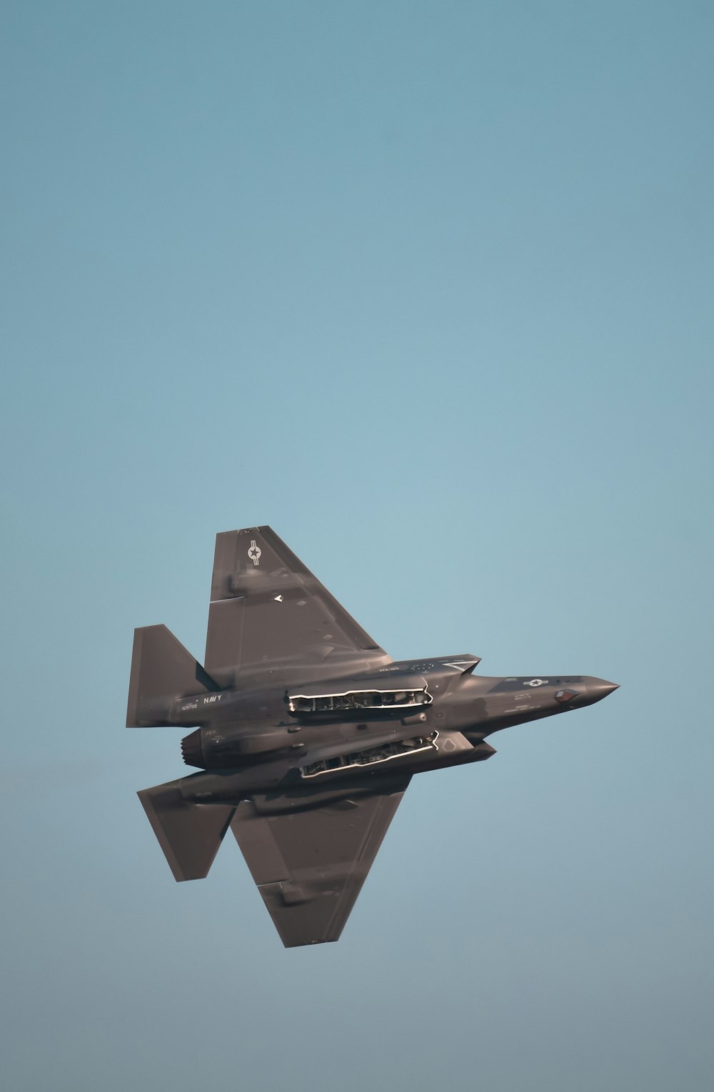 a fighter jet flying through a blue sky