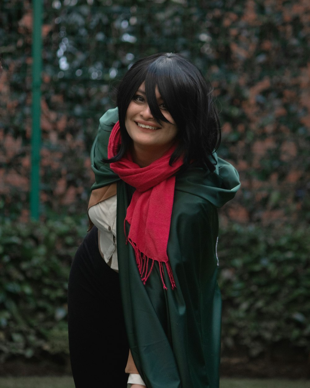 a woman wearing a green coat and a red scarf