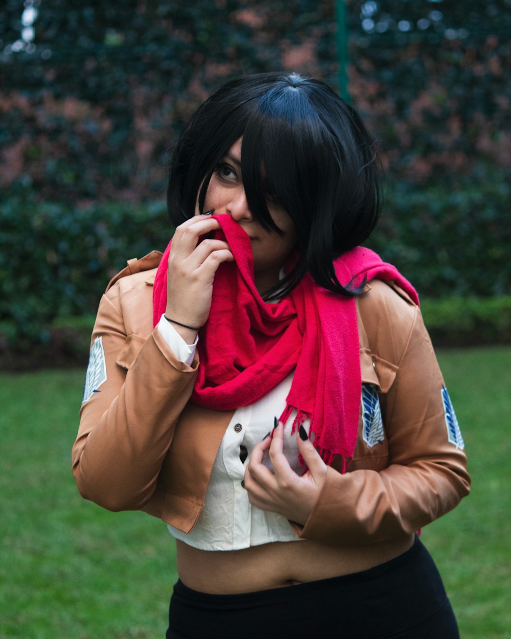 a woman wearing a brown jacket and a red scarf