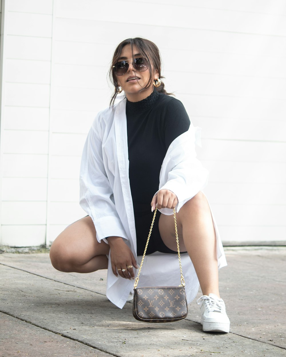 a woman sitting on the ground holding a purse