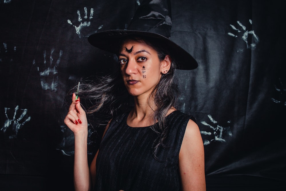 a woman in a witches costume holding a cigarette
