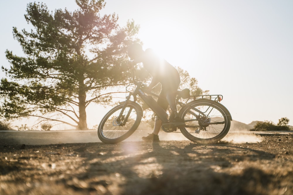 a man riding a bike down a dirt road