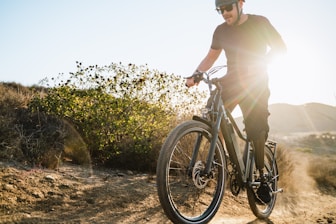 a man riding a bike down a dirt road