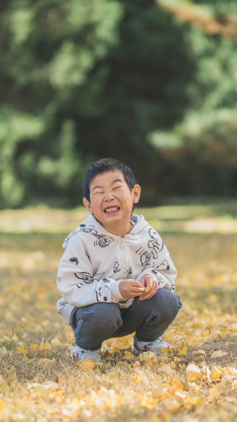 a young boy sitting on the ground laughing
