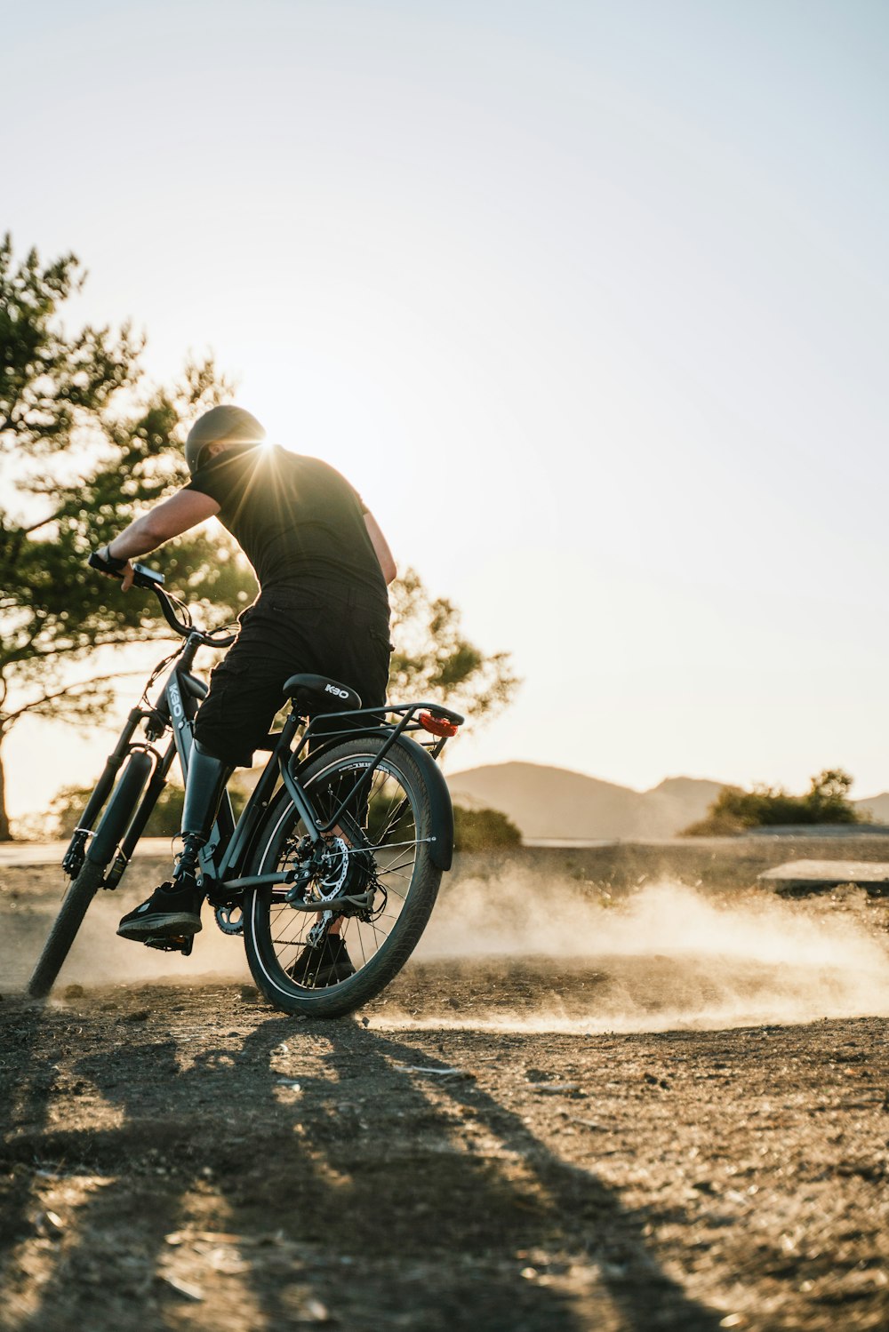 a man riding a bike down a dirt road