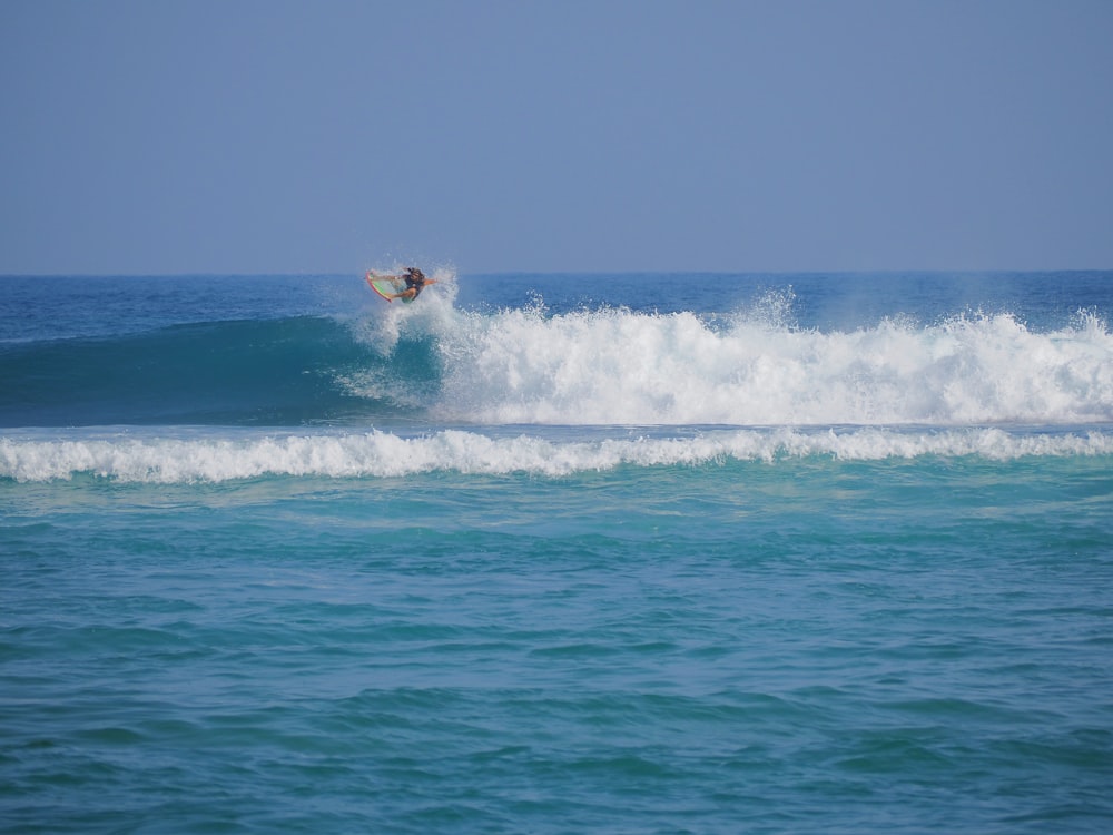 a man riding a wave on top of a surfboard