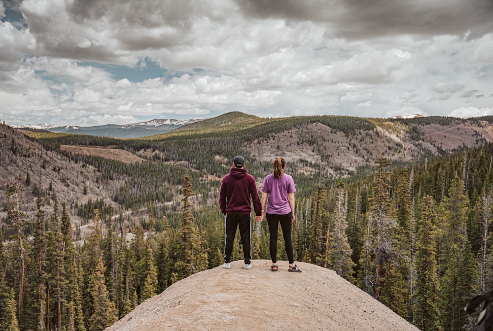 a couple of people standing on top of a mountain