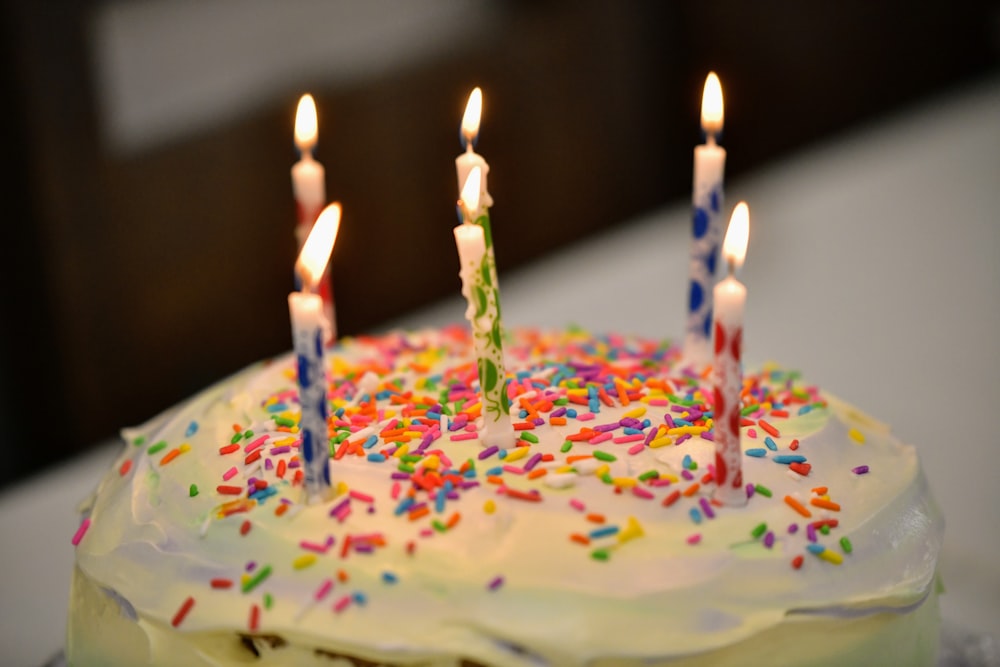 a birthday cake with white frosting and colorful sprinkles