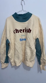 Brightly colored baby sweatshirt hanging on a small wooden hanger