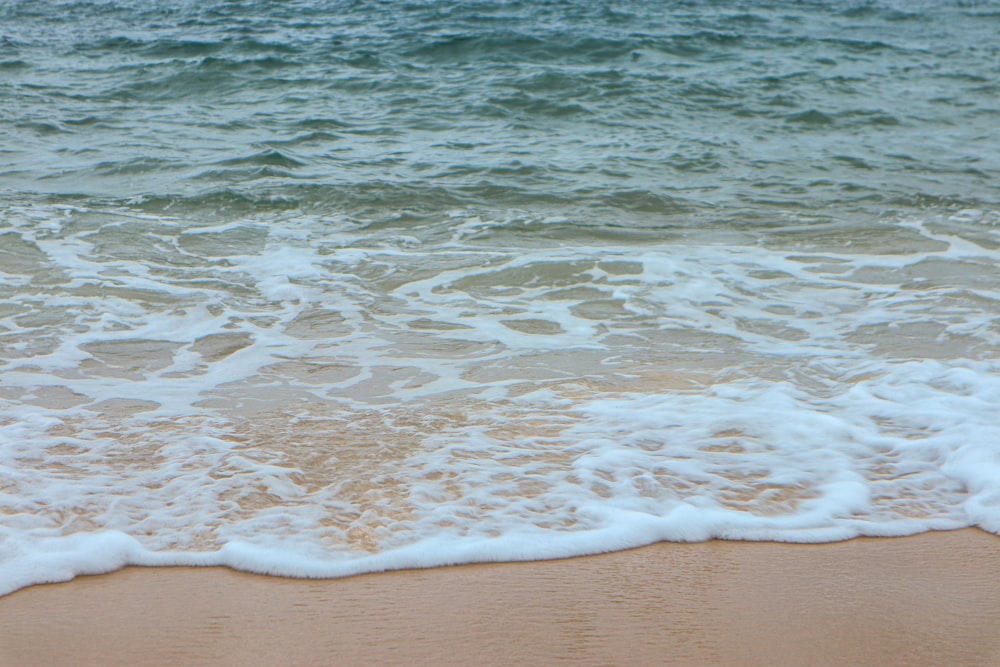 a sandy beach with waves coming in to shore