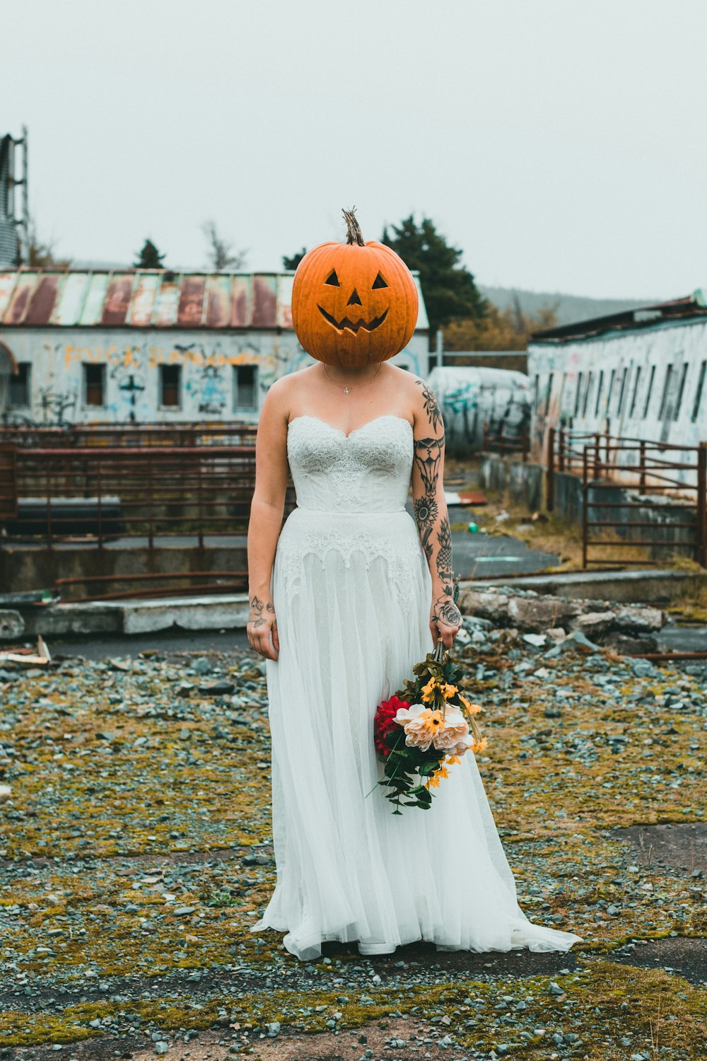 a woman in a white dress with a pumpkin on her head