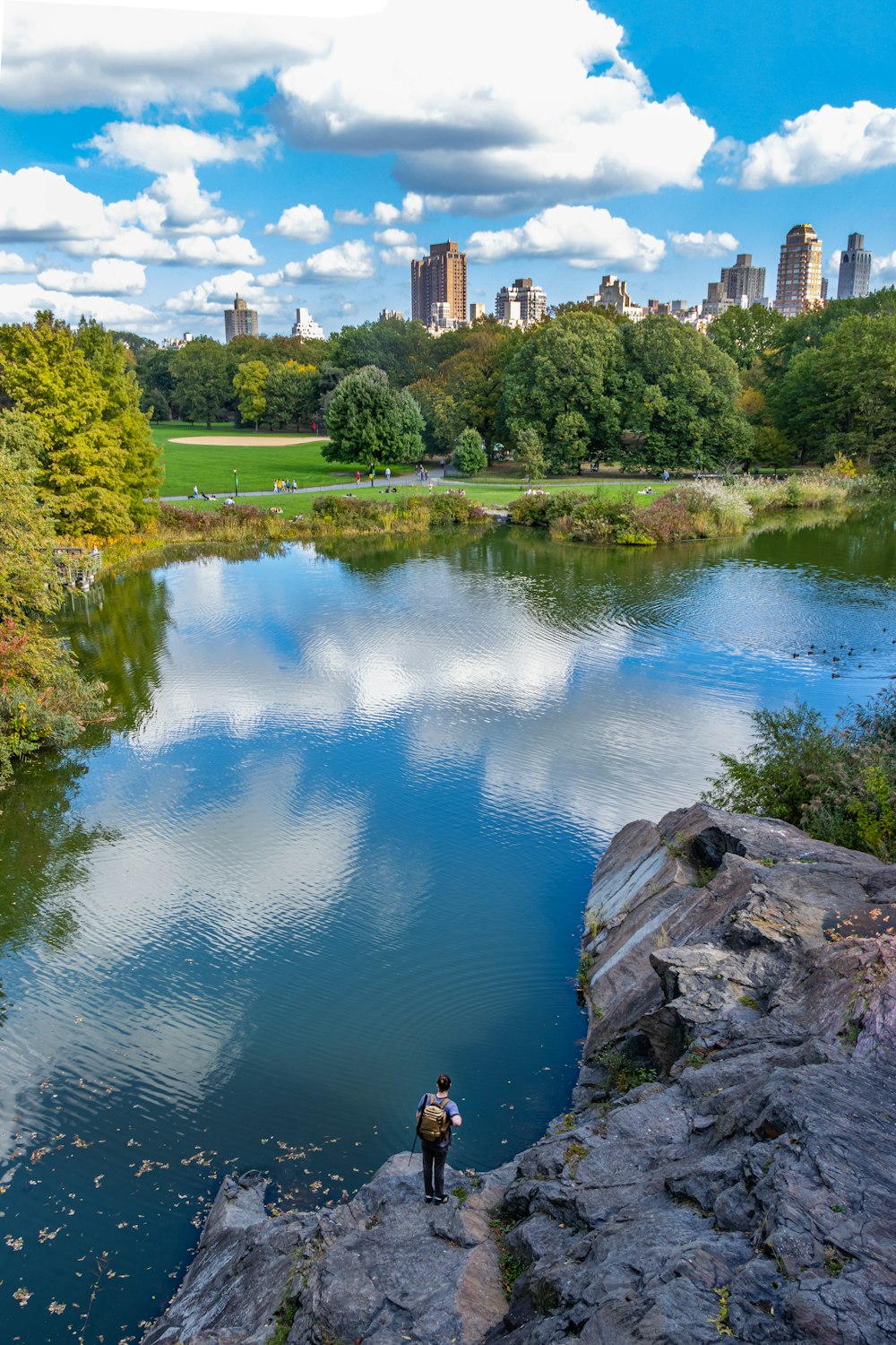 a man standing on a rock next to a body of water