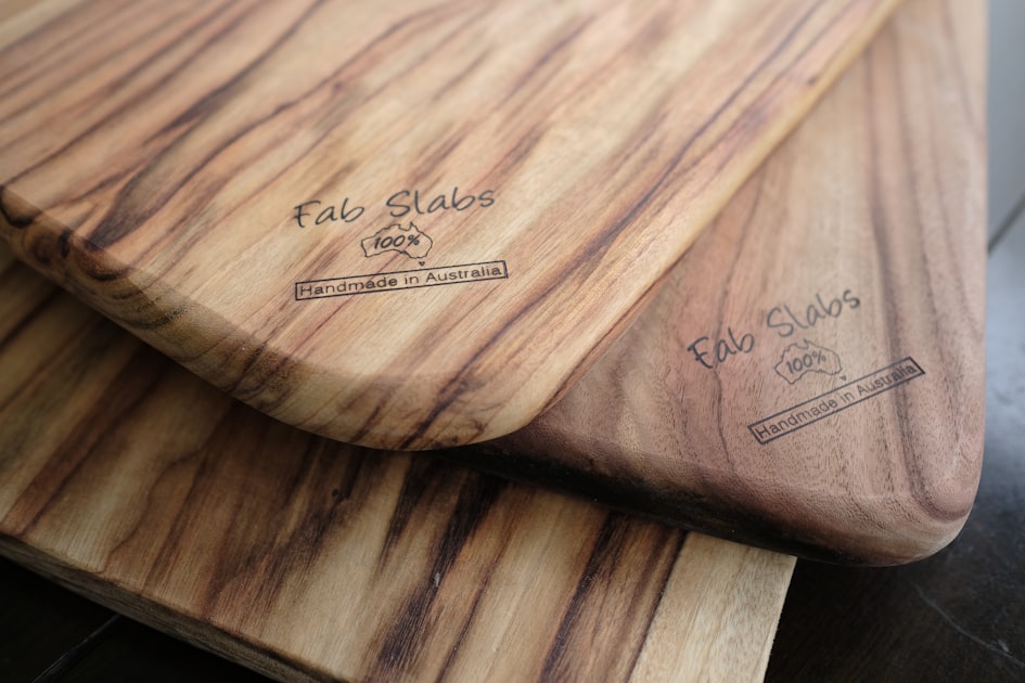 two wooden cutting boards sitting on top of a table