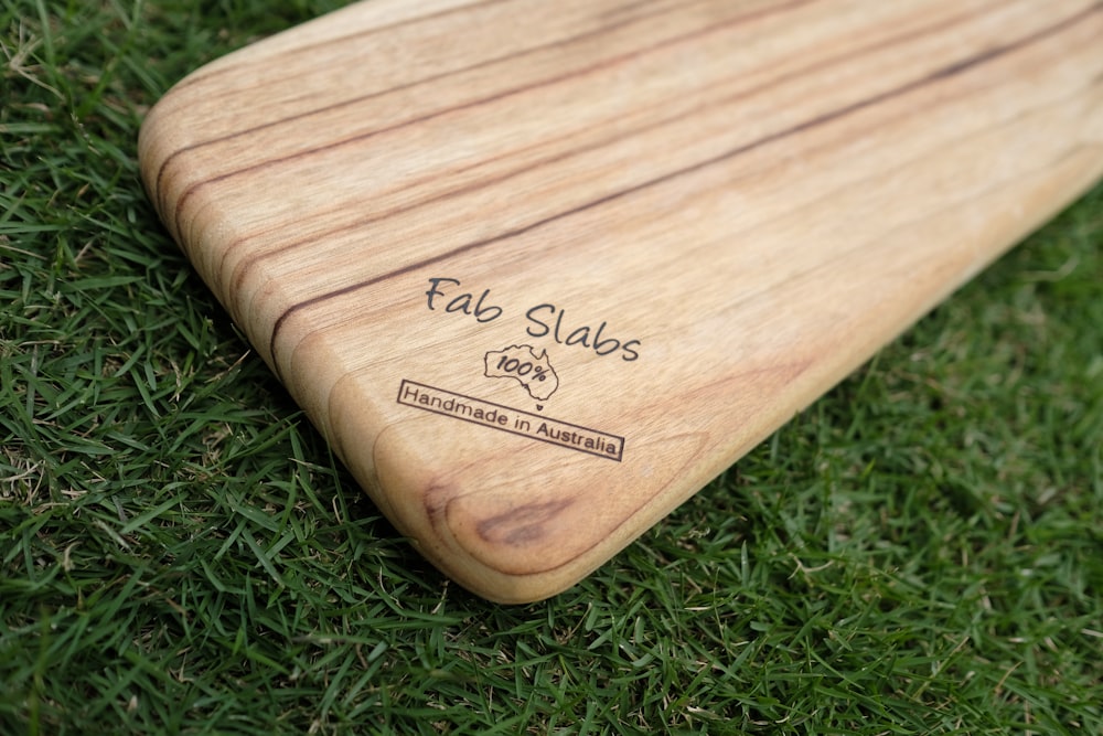 a close up of a wooden board on some grass