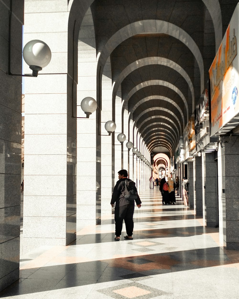 a person walking down a long hallway between two buildings