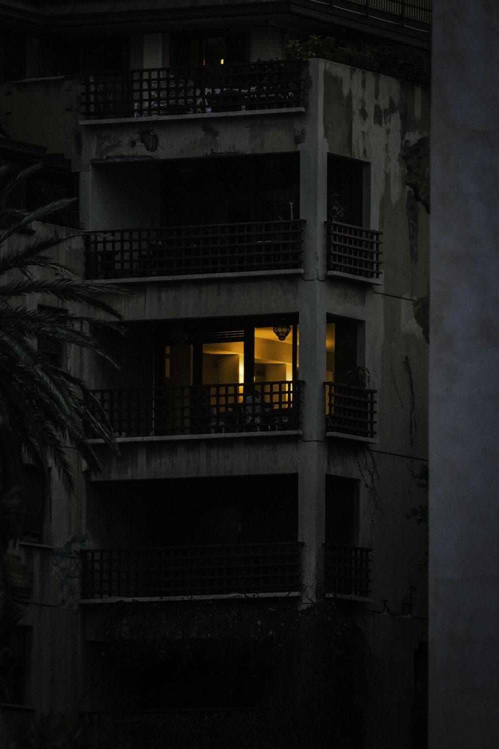 a tall building with balconies lit up at night