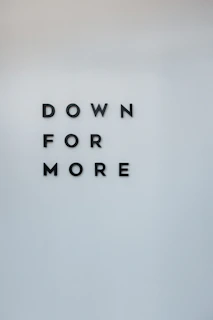 a sign that says down for more on a wall