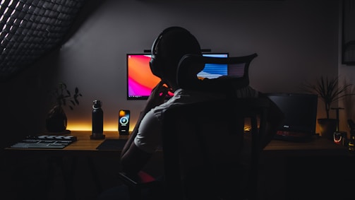 a person wearing headphones sitting in front of a computer