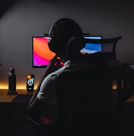 a person wearing headphones sitting in front of a computer