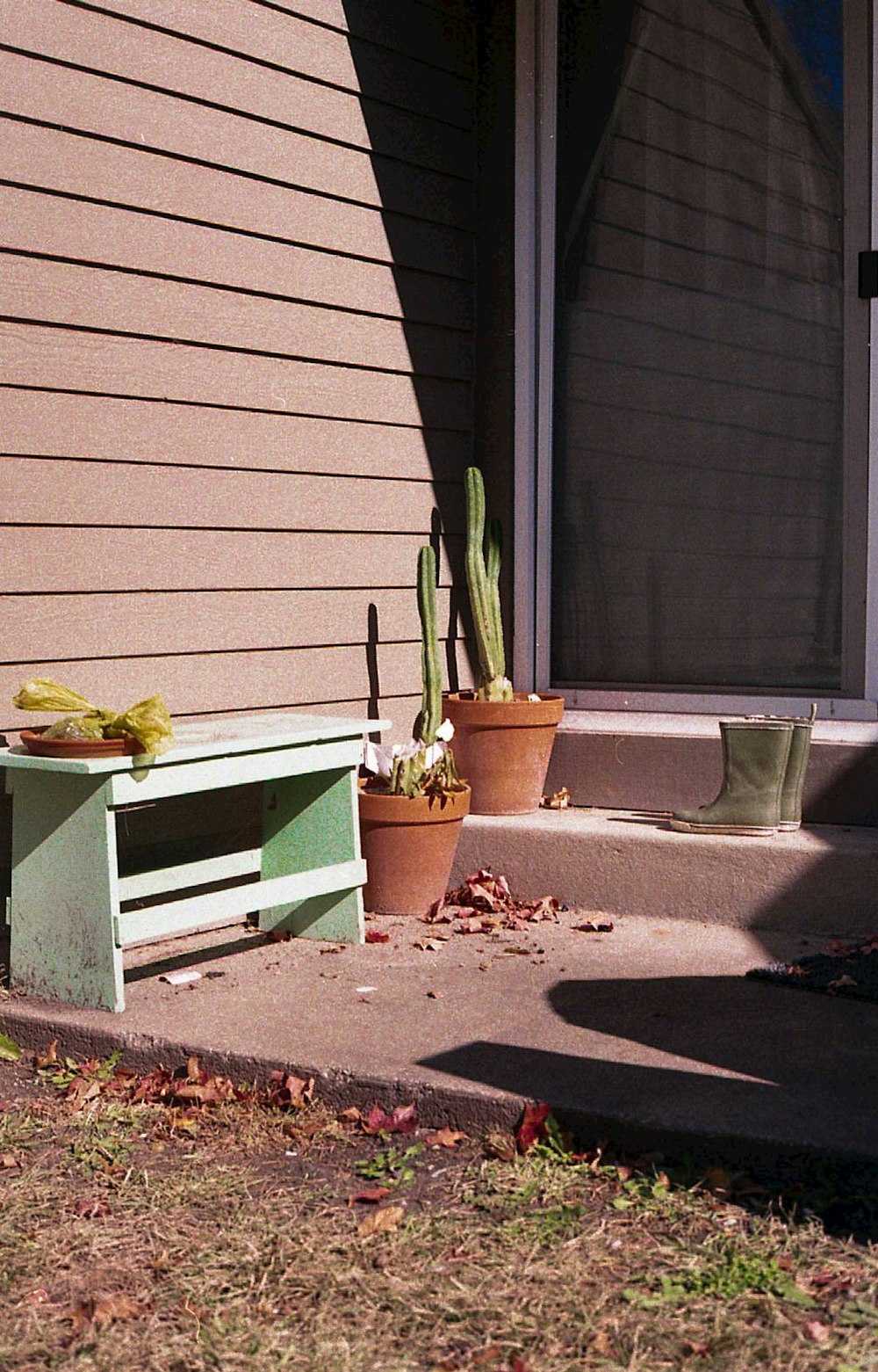a wooden bench sitting on the side of a house