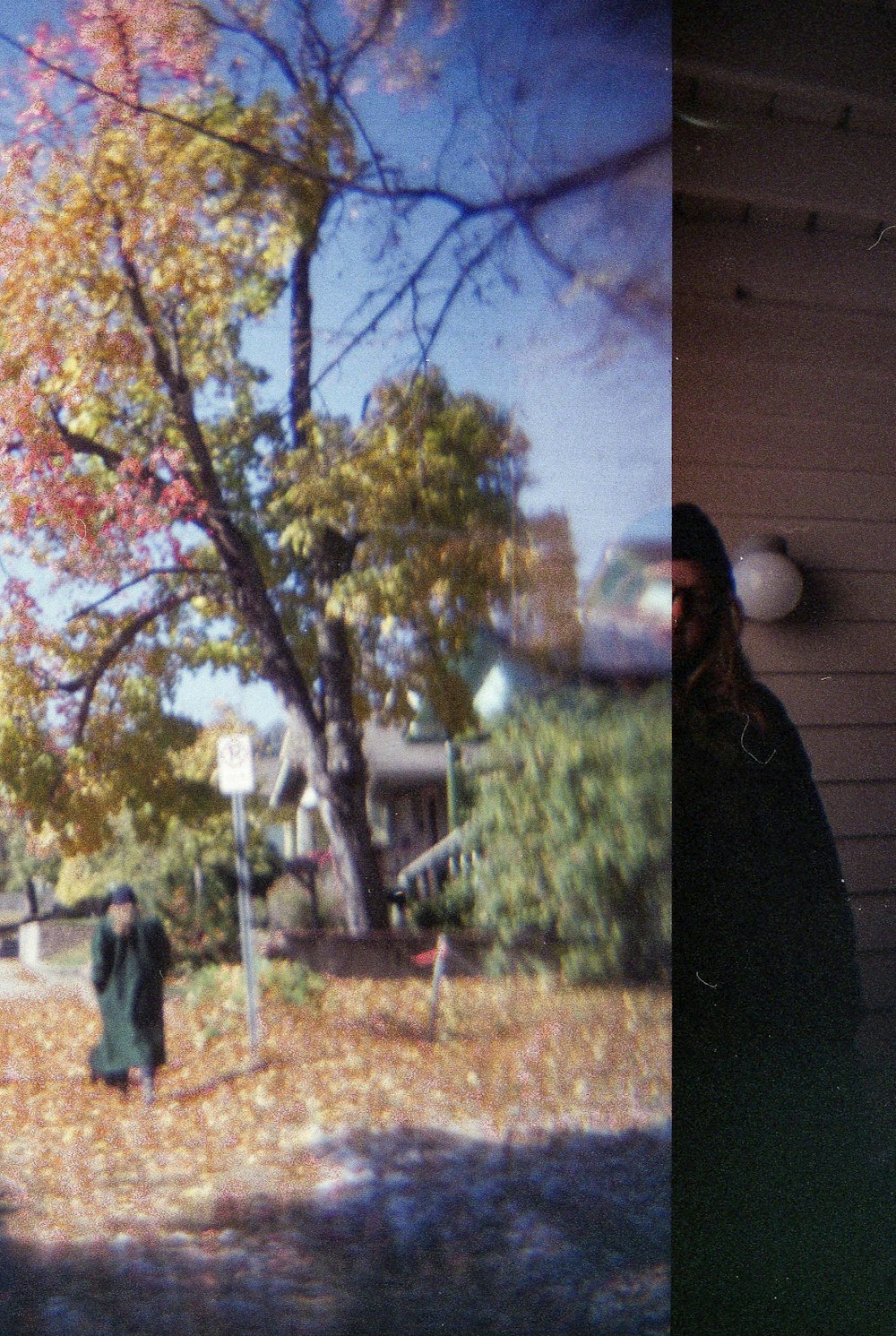 a man standing next to a tree in a yard