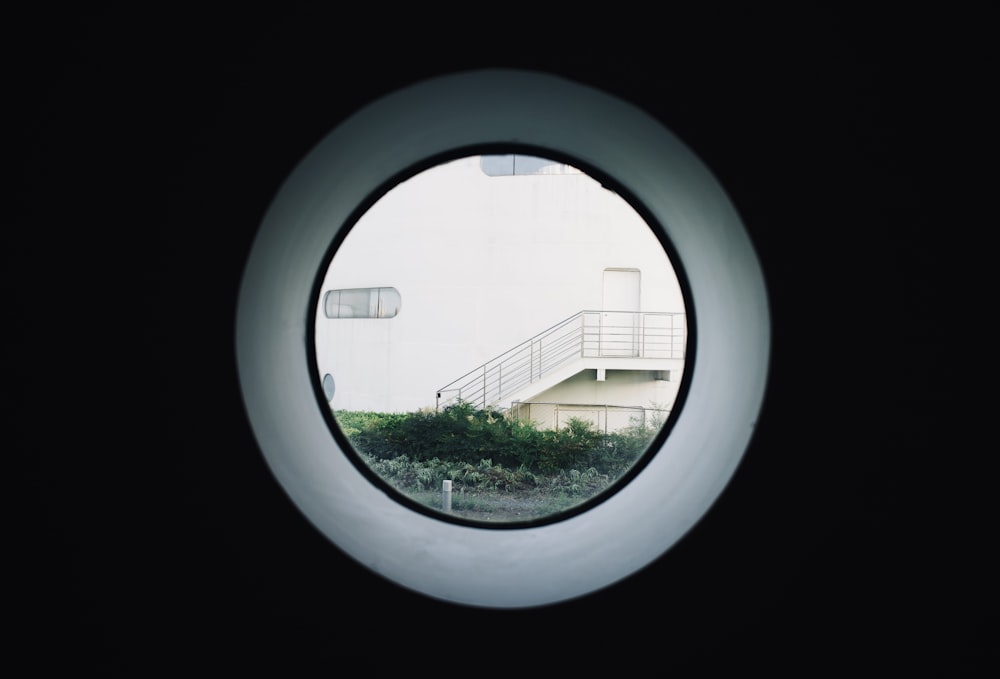 Blick auf ein Gebäude durch ein rundes Fenster