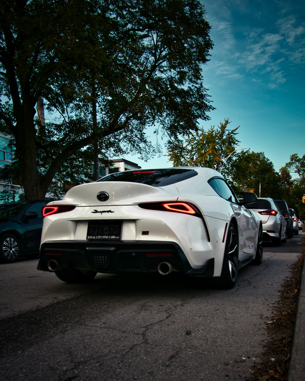 a white sports car parked on the side of the road