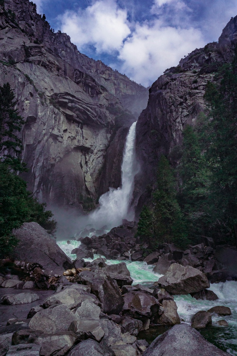 a large waterfall is in the middle of some rocks