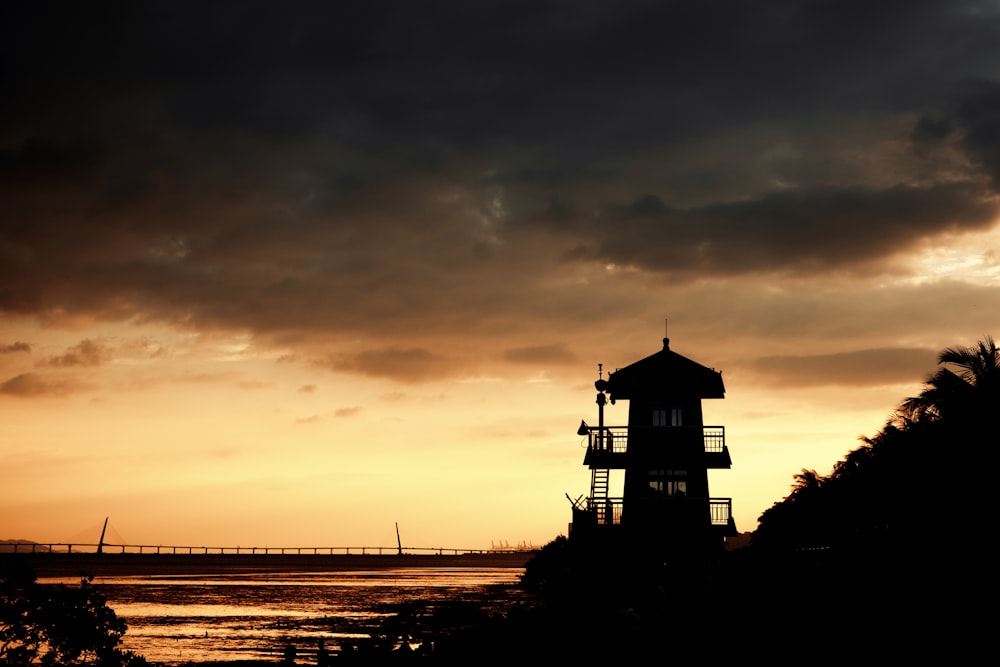 a light house sitting on top of a hill next to a body of water