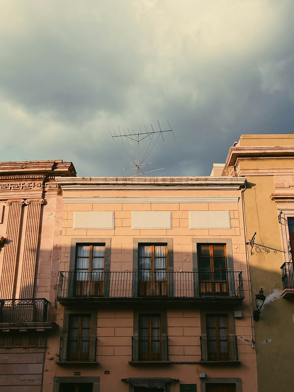 a tall building with windows and a tv antenna on top of it