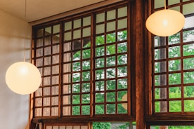 Close-up of handcrafted wooden beams and paper lanterns illuminating the cozy interior of the Sunshine Bay residence.