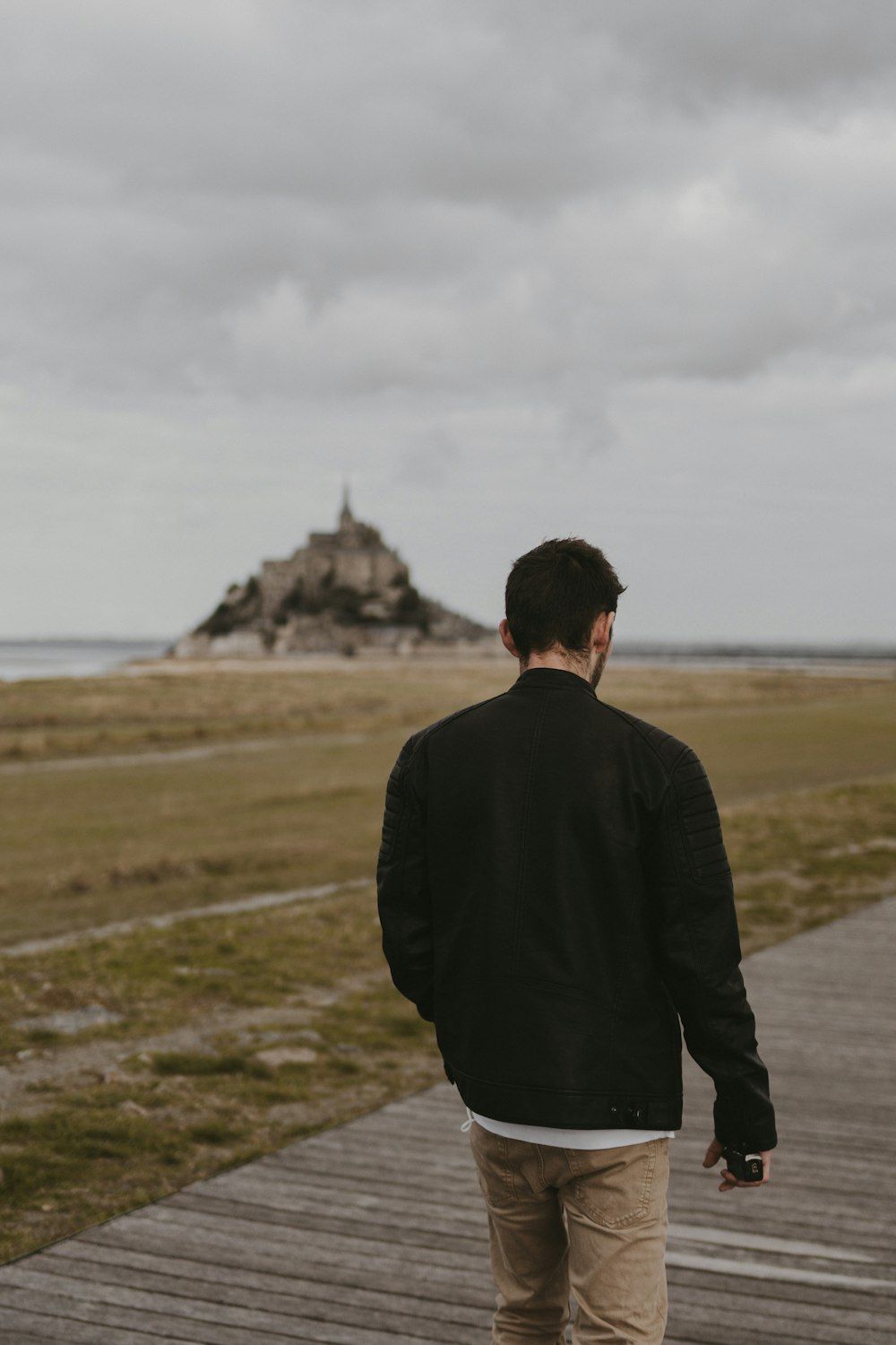 a man standing on top of a wooden walkway