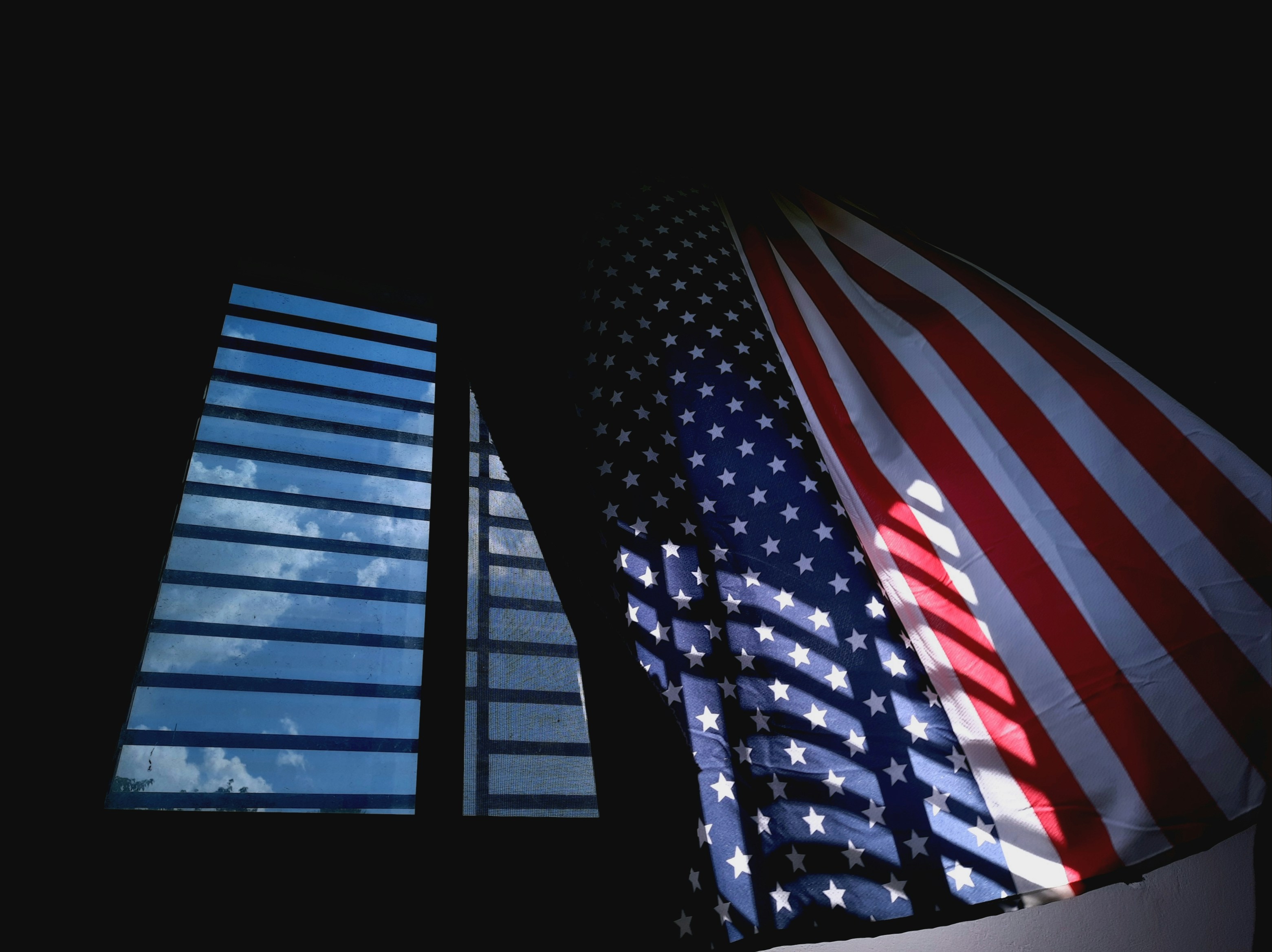 two american flags next to a tall building