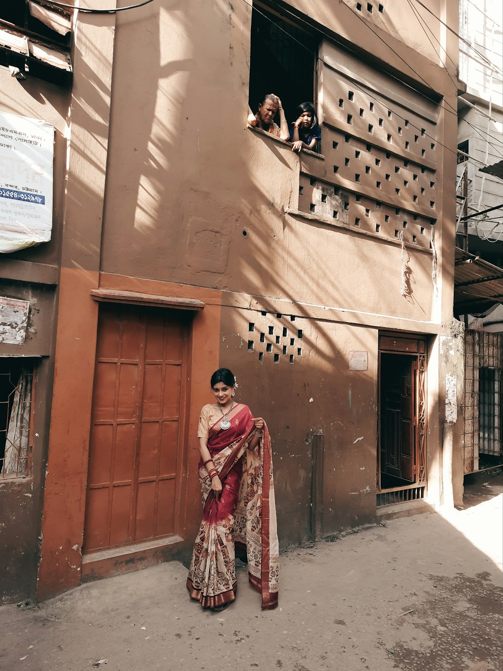 a woman in a sari standing in front of a building