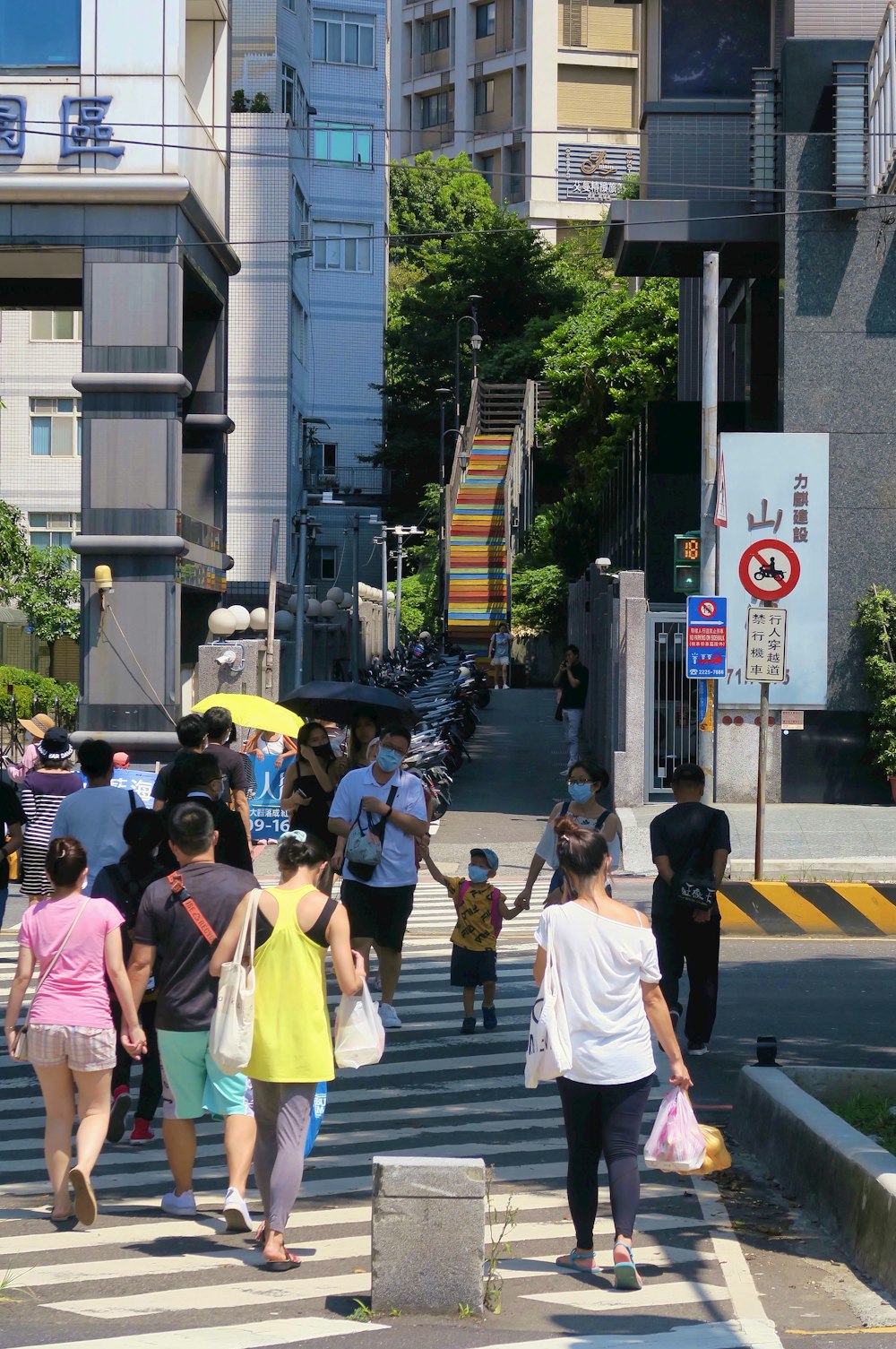 a group of people walking across a cross walk