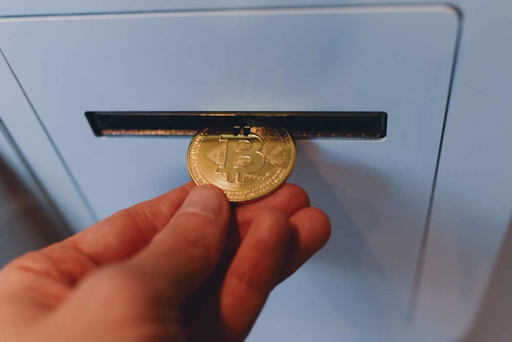 a person is holding a bitcoin in their hand