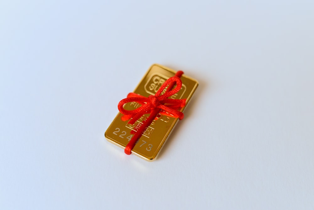 a gold bar with a red ribbon tied around it
