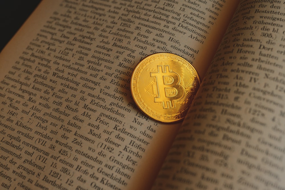 a bit coin sitting on top of an open book