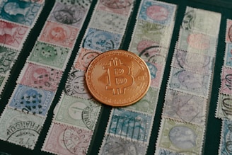 a bit coin sitting on top of a pile of stamps