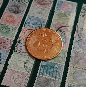 a bit coin sitting on top of a pile of stamps