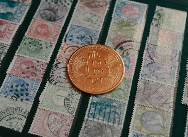 a bit coin sitting on top of a pile of stamps
